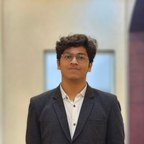 Nishant Borkar in a dark blazer, standing in a hallway.